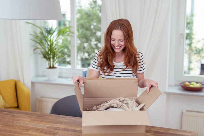 Subscription E-commerce Solutions tailored to your customers’ needs. woman opening a subscription box from elanders americas