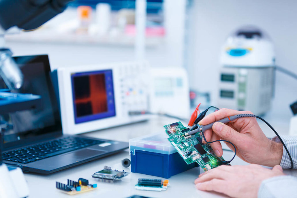 person checking circuit board for defects