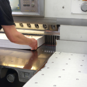 Person cutting large printed sheets